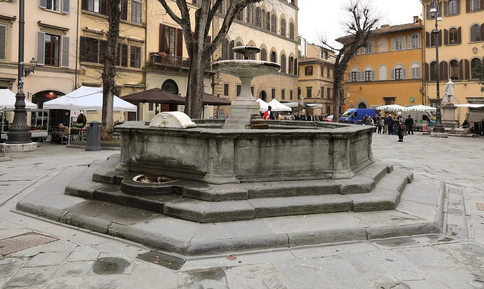 La fontana di Piazza Santo Spirito con i banchi del mercatino domenicale sullo sfondo